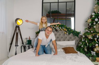 Genç mutlu baba ve küçük kız yeni yıl yatağında.