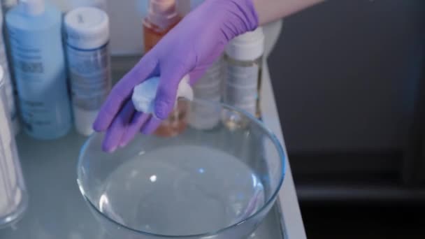 Kvinna kosmetolog fuktar tvättlappar före kosmetisk procedur. — Stockvideo