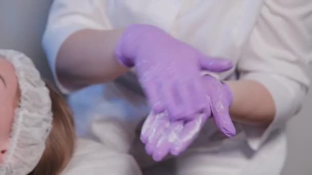 Kvinna kosmetolog gnuggar grädde i händerna. — Stockvideo