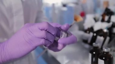 Kadın güzellik uzmanı çözeltiyi antiseptikle tedavi ediyor..