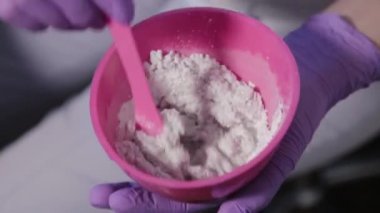 Kadın güzellik uzmanı yüz maskesi hazırlıyor.