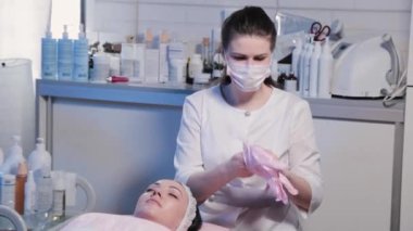 Kadın güzellik uzmanı lastik eldiven takıyor..