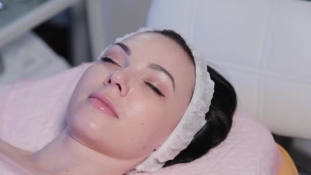Красивая молодая женщина лежит на диване перед косметической процедурой. — стоковое видео