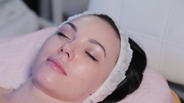 Vacker ung kvinna ligger på en soffa innan en kosmetisk procedur. — Stockvideo
