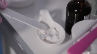 Kadın güzellik uzmanı kavanozlardan krema topluyor..