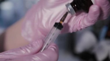 Güzellik uzmanı kadın şırıngayla serum çeviriyor..