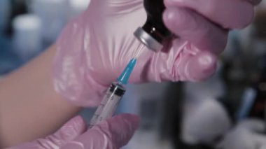 Güzellik uzmanı kadın şırıngayla serum çeviriyor..