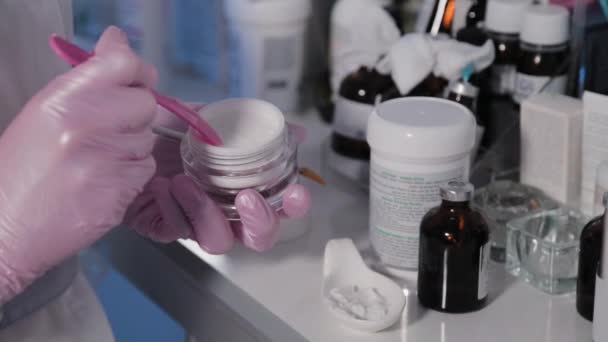 Žena kosmetička sbírá smetanu ze sklenic. — Stock video
