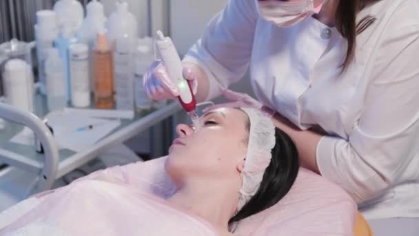 Kvinna kosmetolog gör mekanisk peeling av ansiktet. — Stockvideo