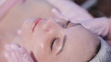 Kadın güzellik uzmanı kadınların yüzünü ovar..