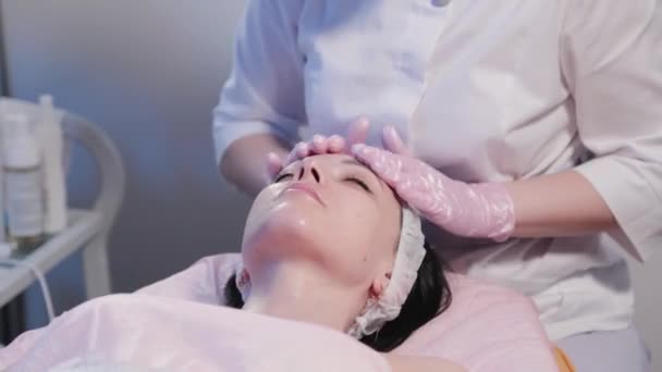 Woman beautician rubs womans face. — Stock Video