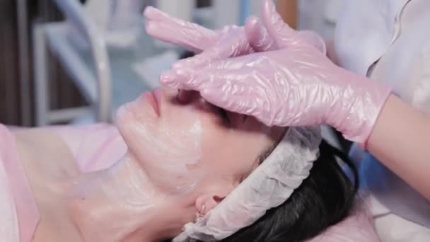 Kosmetikerin reibt Frauen das Gesicht. — Stockvideo