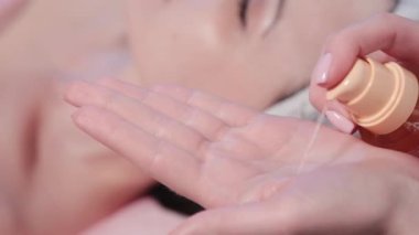 Kadın güzellik uzmanı elinde krema sıkıyor..