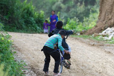 Bazı çocuklar 19 Haziran 2018 'de Pithoragarh, Uttrakhand, Hindistan' da bisikletle şarkı söylüyorlar.