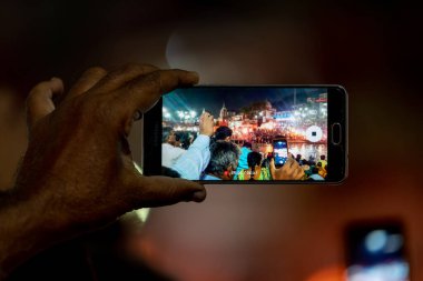 Adam akıllı telefondan video izliyor.