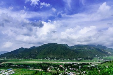 Dağları ve mavi gökyüzü olan güzel bir manzara.