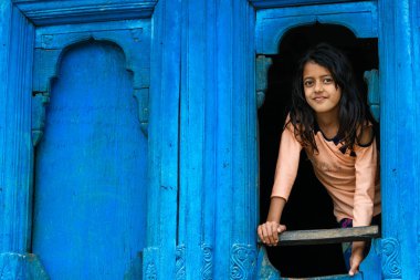 Pithoragarh, Uttrakhand, Hindistan 'da bir retro evin vitrininde sevimli bir kız, 19 Haziran 2018