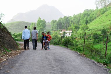 Bazı çocuklar 19 Haziran 2018 'de Pithoragarh, Uttrakhand, Hindistan' da bisikletle şarkı söylüyorlar.