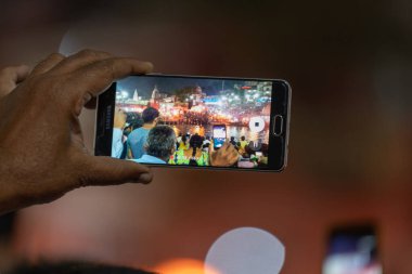 Adam akıllı telefondan video izliyor.