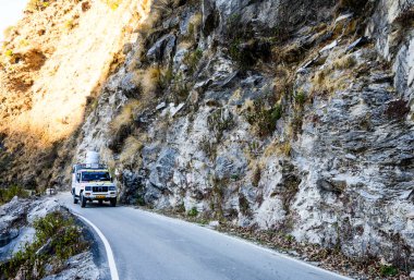 Dağlarda asfalt yolda bir araba