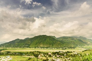 Dağları ve bulutlu gökyüzü olan güzel bir manzara.
