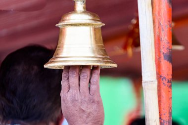 Budist tapınağında çan tutan bir el.