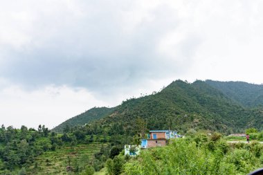 Dağları ve bulutlu gökyüzü olan güzel bir manzara.