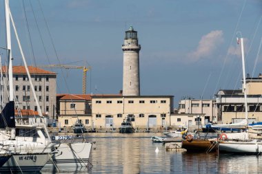 Kuzey İtalya 'daki Trieste' deki eski deniz feneri La Lanterna 'ya giden yat limanının teknelerine bakın.