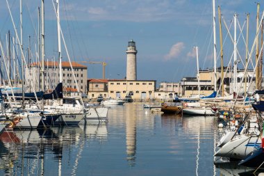 Kuzey İtalya 'daki Trieste' deki eski deniz feneri La Lanterna 'ya giden yat limanının teknelerine bakın.
