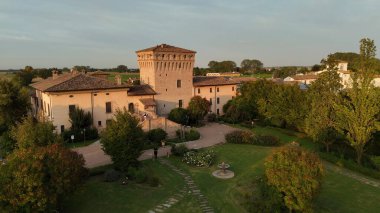 Piacenza, İtalya - 7 Eylül 2025 Orta Çağ 'da yemyeşil bahçeler, fıskiyeler ve ağaçlarla çevrili yüksek bir ortaçağ yapısına sahip tarihi İtalyan villası