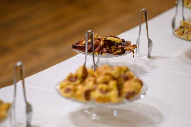 Lezzetli Tatlı Pastalar ve Tatlılar Beyaz bir masa örtüsünde sunuldu Bir Kutlama ya da Parti Servisi İştah açıcı Yemek Deneyimi Olarak