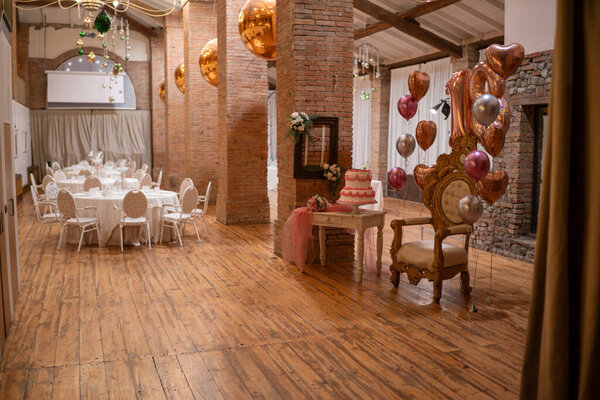 Элегантный бальный зал, украшенный для особого празднования дня рождения тортом с воздушными шарами и рассадкой гостей