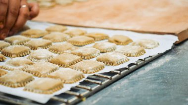 Lezzetli bir İtalyan yemeği pişirmeye hazır un serpiştirilmiş fırın tepsisi üzerinde ev yapımı makarna kareleri.