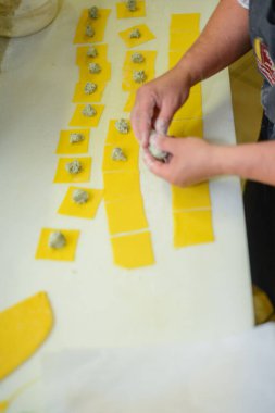 Profesyonel Mutfak Ortamı Gösterisinde Temiz Beyaz Bir Yüzeye Doldurulmuş Taze Ravioli Pastası Yapan Yetenekli Eller Sanatsal Gıda Hazırlama