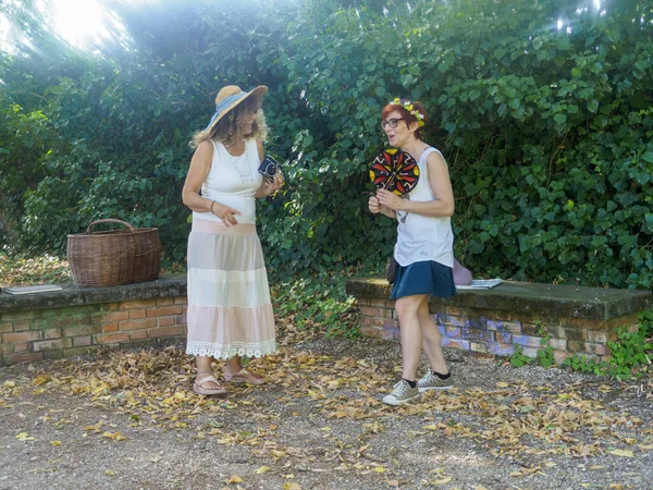 Yazın Giyinen İki Kadın Açık havada Yeşillik ve Doğal Güneş Işığı Altında Sohbet Ediyor