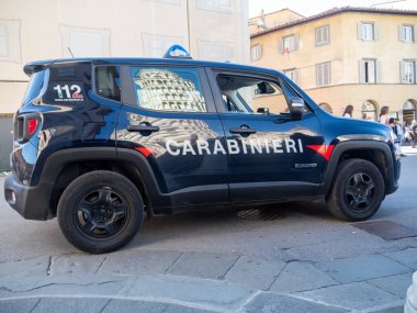 Pisa, İtalya - 16 Ekim 2025 Jandarma Jeep Renegade askeri polis aracı şehir caddesinde park halinde, Eğik Pisa Kulesi 'nin yansımasını gösteriyor.