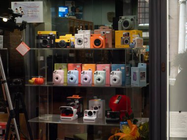 Pisa, İtalya - 16 Ekim 2025 Dükkan önünde hazır kameraların çeşitliliği: Fotoğrafçılık suyu satın almak isteyen müşteriler için sergi üzerine parlak renkli Fujifilm Instax ve Polaroid demetleri