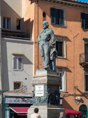 Pisa, İtalya - 16 Ekim 2025 Giuseppe Garibaldi bronz heykeli Pisa meydanında tarihi Toskana binaları ve şehrin üzerinde açık mavi gökyüzü