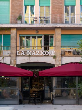 Pisa, İtalya - 16 Ekim 2025 Street ve tarihi şehir merkezi Pisa, İtalya 'da cephe inşa. La Nazione gazete ofisi ve tenteli perakende mağazaları