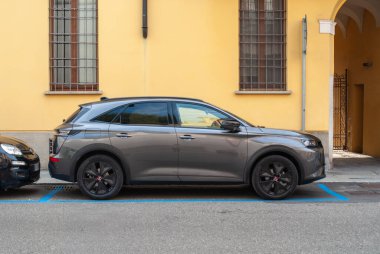 Cremona, İtalya - 2 Ekim 2025 DS 7 Crossback SUV işaretli bir şehir caddesinde park halinde, sarı bir binaya karşı zarif bir modern tasarım sergiliyor.