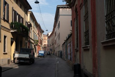 Cremona, İtalya - 2 Ekim 2025 Picturesque tarihi Avrupa caddesi kapalı panjurlu ve öğleden sonra güneşinin yumuşak parıltısıyla aydınlatılan antika balkonlu uzun binalar