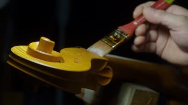 Çello parşömenlerini daha dikkatli cilalamak, titiz marangozluk teknikleri ve zanaatkarlık atölyesinde geleneksel enstrüman işçiliği sergilemek.