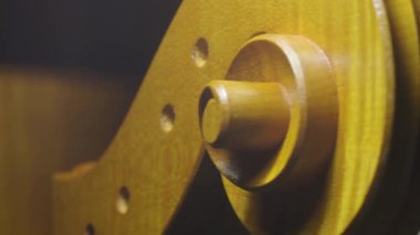 Luthier atölyesinde özel aletler ve vernik kullanarak çello tomarını titizlikle hazırlıyor. İşlemin karmaşık detaylarını gösteriyor.