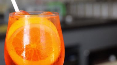 Buzlu soğuk spritz kokteyli, yanında aperatif kâsesi günbatımında moda kafede, ahşap bar tezgahında dinleniyor.