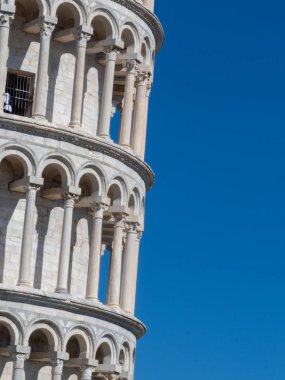 Pisa, Toskana - 16 Ekim 2025 Eğik Pisa Kulesi, İtalya 'daki canlı mavi gökyüzüne karşı antik Romanesk tasarımını sergiliyor.