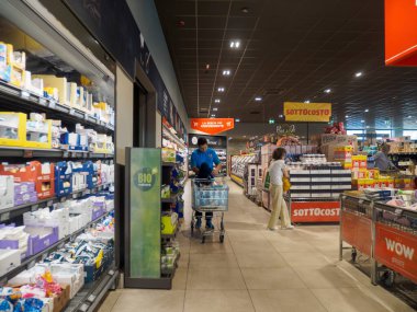 Cremona, İtalya - 17 Eylül 2025 Lombardiya İtalya 'da modern indirimli bir süpermarketin içindeki koridor çok çeşitli gıda ürünleri ve ev gereçlerini müşterilerle birlikte sergiliyor.