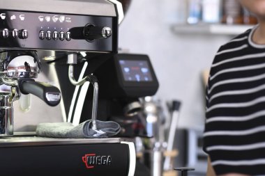 Cremona, İtalya - 21 Temmuz 2025 Profesyonel kahve makinesi Parlak modern bir kafede aromatik içecekler demlemek için sıcak su hazırlıyor