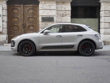 Cremona, İtalya 14 Ağustos 2025 Lüks gri Porsche Macan tarihi Torino binalarının yakınında konumlandı ve klasik mimari arkaplana karşı şık şehir tasarımı sergiliyor.