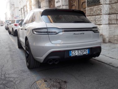 Cremona, İtalya 14 Ağustos 2025 tebeşir renkli bir Porsche Macan GTS 'nin arka görüntüsü bir şehir caddesine park edilmiş, diğer park halindeki araçlarla birlikte spor tasarımı ve güçlü egzoz sistemini sergiliyor.