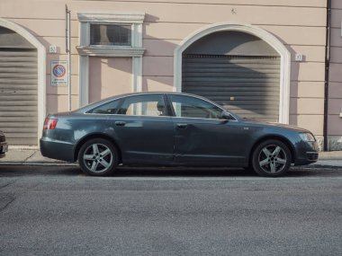 Cremona, İtalya 14 Ağustos 2025 Koyu Gri Audi A6 bir şehir caddesine park edilmiş ve arka planda ikametgah binası bulunan lüks tasarımı ve kentsel bütünleşmesi sergilenmektedir.